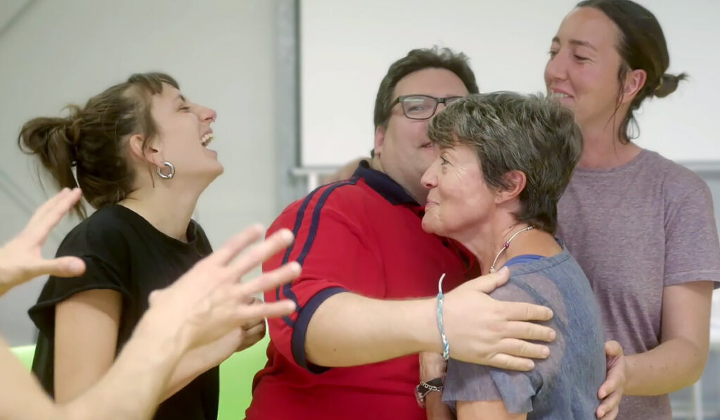 Partecipanti al laboratorio di teatro della fondazione Di Liegro che si abbracciano durante un esercizio